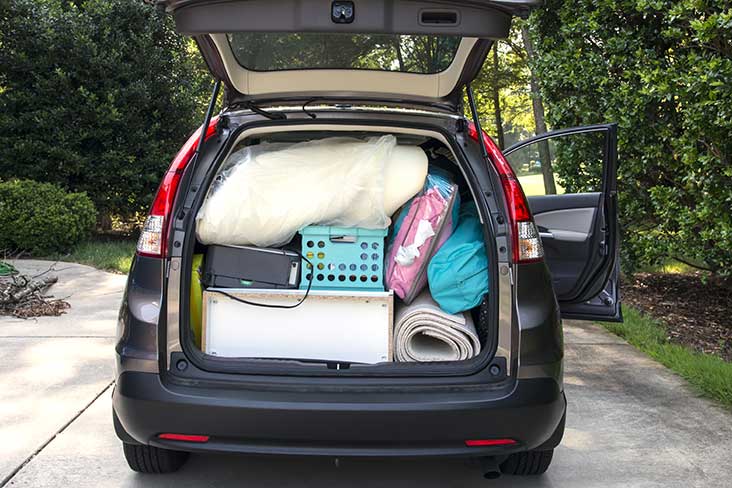  the trunk of a car full of blankets and bins